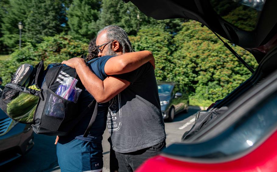 A Coast Guard Academy cadet embraces a loved one