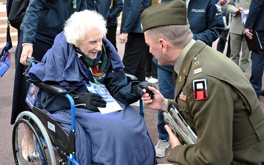 A soldier shakes a woman’s hand.