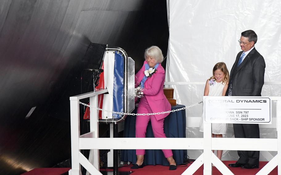Christie Vilsack, sponsor of the pre-commissioning unit USS Iowa, christens the ship during a ceremony at General Dynamics Electric Boat shipyard facility in Groton, Conn., Saturday, June 17, 2023.