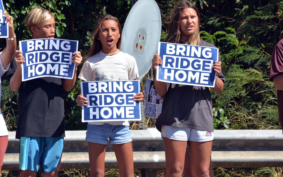 Supporters of Navy Lt. Ridge Alkonis, sentenced in the summer to three years in a Japanese prison, beckon to vehicles entering and exiting Camp H.M. Smith, Honolulu, Aug. 31, 2022.