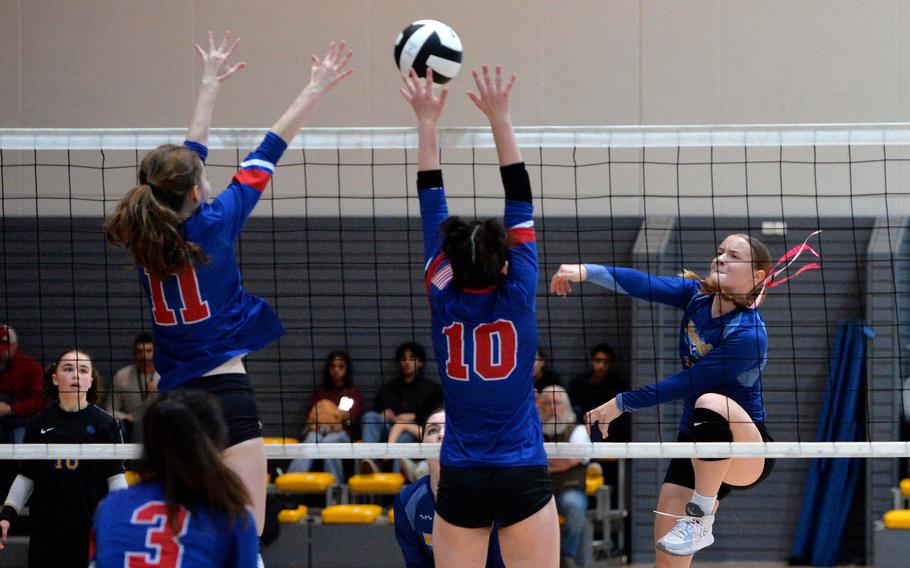 Wiesbaden’s Rylee Ashcroft hits the ball past Ramstein’s Kaitlyn Rex, left, and MJ Davis at the DODEA-Europe volleyball finals in Ramstein, Germany, Oct. 28, 2023. The Warriors took the Division I title with a 25-18, 12-25, 25-16, 22-25,15-13 win over the Royals.