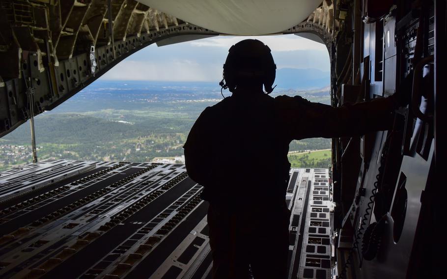 An airman observes terrain from the back of an aircraft