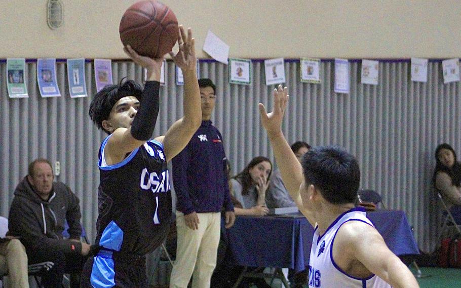 Osan's Jayden Hightower shoots over Dwight School of Seoul's Jeremiah Oh during Wednesday's Korea boys basketball game. The Lions won 53-44 despite Hightower's 24 points.
