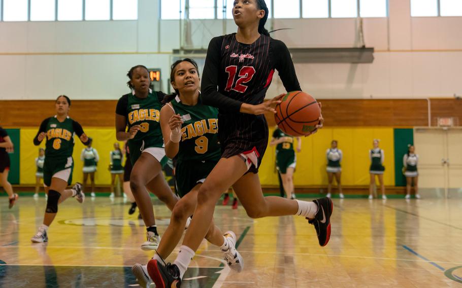 Nile C. Kinnick's KaMiyah Dabner drives to the basket past Robert D. Edgren's Maliyah Magat during Saturday's DODEA-Japan girls basketball game. The Red Devils won 42-9 to complete the two-game weekend sweep.