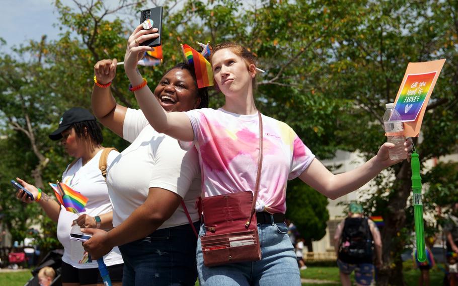 People stop for a selfie during a Pride Day parade at Yokosuka Naval Base, Japan, Wednesday, June 28, 2023.