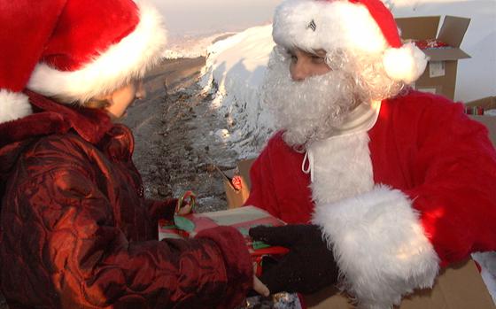 BANOVICI, Bosnia and Herzegovina, Dec. 25, 2001: Six-year-old Selma Mesic, a Muslim refugee living near Camp Comanche in Bosnia and Herzegovina receives Christmas gifts from Santa Claus, also known as Sgt. Troy Patterson of Bravo Company, 2nd Battalion, 224th Aviation Brigade, on Christmas Day.

META TAGS:  Bosnia and Herzegovina, peacekeeping force, United Nations, U.S. Army, Holidays, Christmas