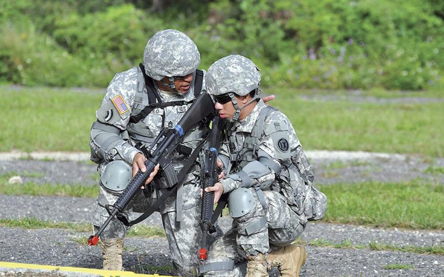 Master Sgt. Fa’amanu Teofilo provides guidance to Pvt. Dilikan Santos during a field training exercise. 