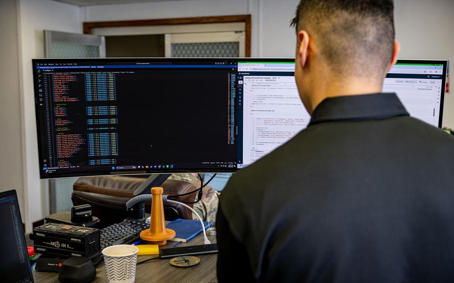 An airman coding on a computer.