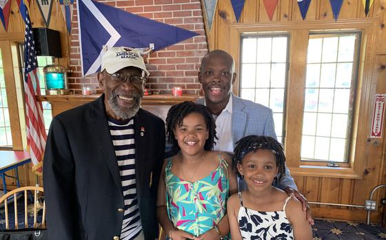 Bill Pinkney, left, poses with a family at the Jackson Park Yacht Club in Chicago, Ill. in 2023. A former Navy sailor, Pinkney battled storms, dehydration, sleep deprivation and loneliness while sailing alone around the world, becoming the first Black sailor to do so by way of a treacherous route around Cape Horn. He died Aug. 31.