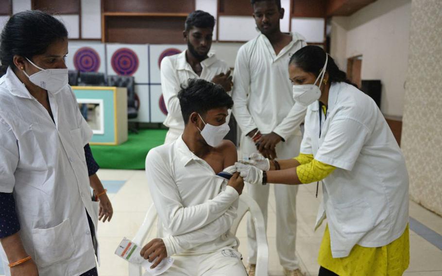 A health worker inoculates a young cricketer with the jab of Covishield vaccine against the COVID-19 coronavirus during a vaccination drive at Rajiv Gandhi International Cricket Stadium in Hyderabad on June 28, 2021. 