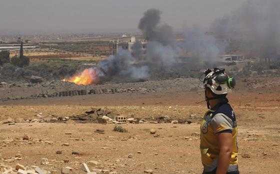 In this photo provided by the Syrian Civil Defense White Helmets, a Syrian Civil Defense worker checks the explosion scene in Maarat Misrin village, in Idlib province, north Syria, Thursday, July, 24, 2025. (Syrian Civil Defense White Helmets via AP)