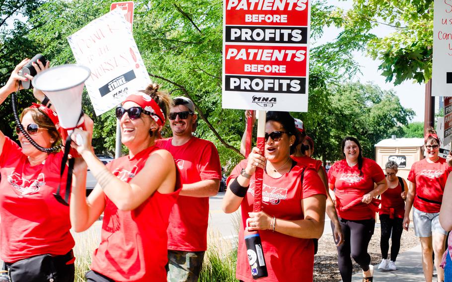 Striking nurses demonstrate for better working conditions on the public sidewalks outside Riverside Hospital on Sept. 13, 2022, in Minneapolis.