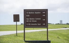 A sign reads “18th Munitions Squadron,” “EOD,” “Navy Munitions Command EAD Unit Okinawa,” and “10 RSG Ammunition Depot.”