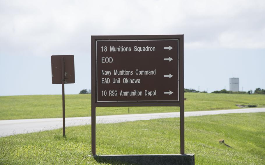 A sign reads “18th Munitions Squadron,” “EOD,” “Navy Munitions Command EAD Unit Okinawa,” and “10 RSG Ammunition Depot.”