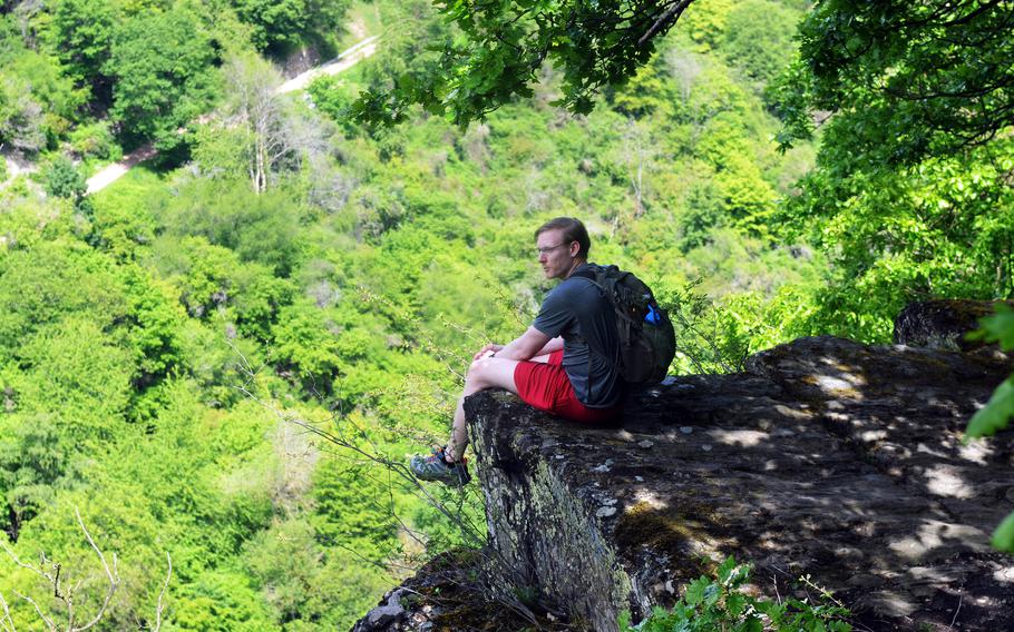 Joshua Seaman, a U.S. soldier based in Wiesbaden, Germany, sits on a cliff on the RheinBurgenWeg hiking trail near the town of Bad Salzig, June 5, 2021.