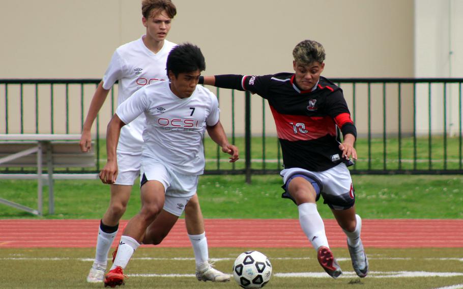Okinawa Christian’s Jarin Ferido and King’s Damian Perez chase the ball during Tuesday’s boys Division II soccer match. The Cobras won 4-1.