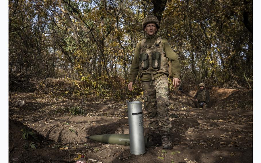 A Ukrainian soldier stands near a shell casing at a howitzer position in the Donetsk region on Oct. 23, 2023. 