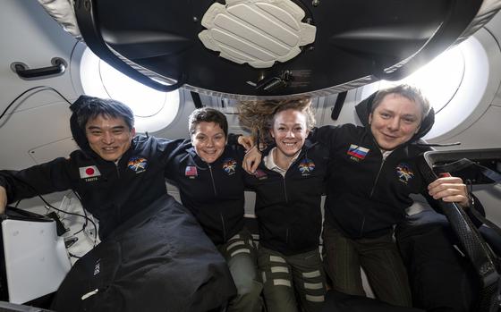 This image provided by NASA shows, from left, NASA's SpaceX Crew-10 members JAXA (Japan Aerospace Exploration Agency) astronaut Takuya Onishi, NASA astronauts Anne McClain and Nichole Ayers, and Roscosmos cosmonaut Kirill Peskov posing for a portrait inside the SpaceX Dragon crew spacecraft that carried them to the International Space Station and will return them back to Earth. (NASA via AP)
