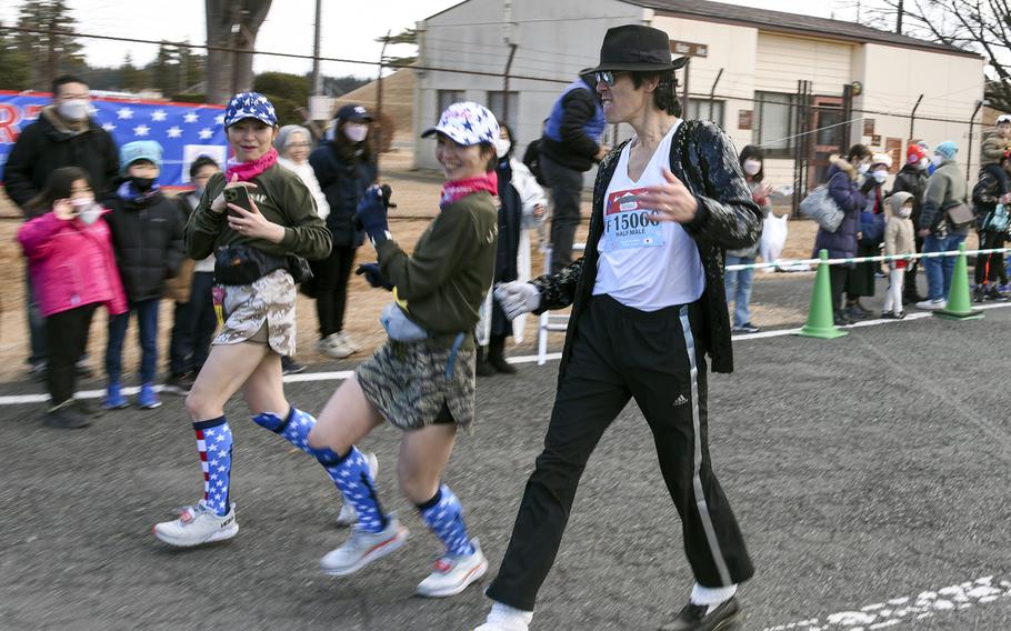 Runners, including one dressed as Michael Jackson, participate in a half-marathon during the 42nd annual Yokota Striders Frostbite Road Race at Yokota Air Base, Japan, Sunday, Jan. 22, 2023.