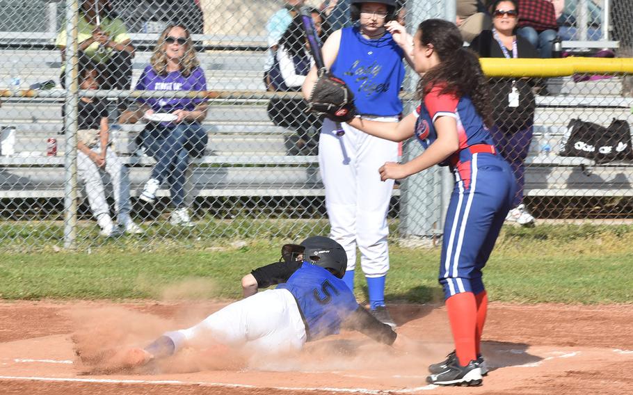 Hohenfels' Maia Brewer scores her team's only run Friday, April 28, 2023, before Aviano pitcher Sophia Scavo can get the ball back from the catcher.