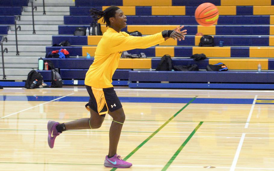 Senior Jai Bailey is throwing a basketball on the court.