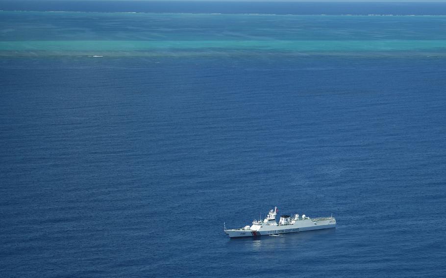 This photo taken on Sept. 28, 2023, shows an aerial view of a Chinese coast guard ship on patrol near the Chinese-controlled Scarborough Shoal (background) during a maritime surveillance flight by the Philippine Bureau of Fisheries and Aquatic Resources over disputed waters of the South China Sea.