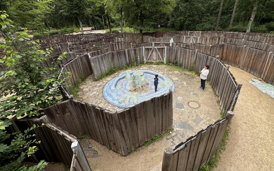 A girl poses for a photo at the fountain in the playground maze at the foot of the Goetheturm, a sightseeing tower in the woods on the south side of Frankfurt.