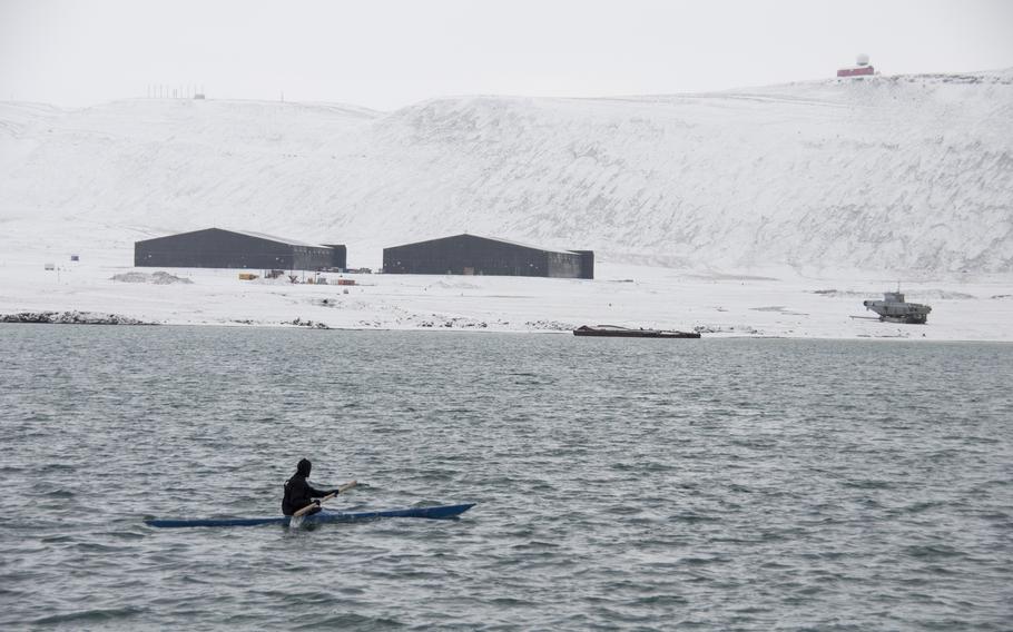 Malik Kleist paddles his kayak toward a demonstration, past two hangars on Thule Air Base used in the Clint Eastwood film “Firefox.” 