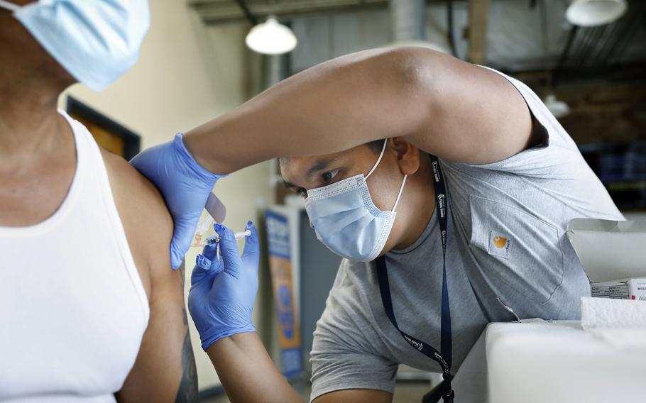 A registered nurse with the Los Angeles Department of Public Health administers a COVID-19 booster at a vaccination clinic at The Village Mental Health Services in Los Angeles in August 2022. 