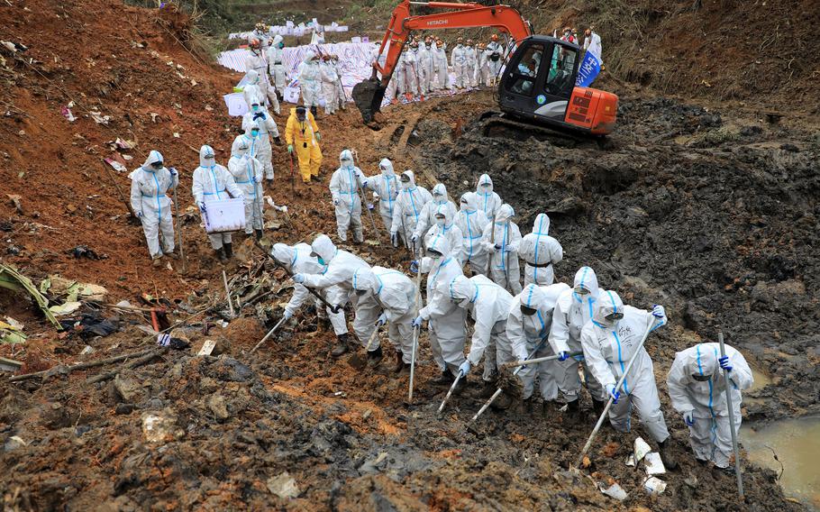Paramilitary police officers comb through the site of where China Eastern flight MU5375 crashed, in Wuzhou, China. The Boeing 737-800 was flying between the cities of Kunming and Guangzhou on March 21, 2022, when it nosedived into a mountainside, disintegrating on impact and killing all 132 people on board. (CNS/AFP/Getty Images/TNS)