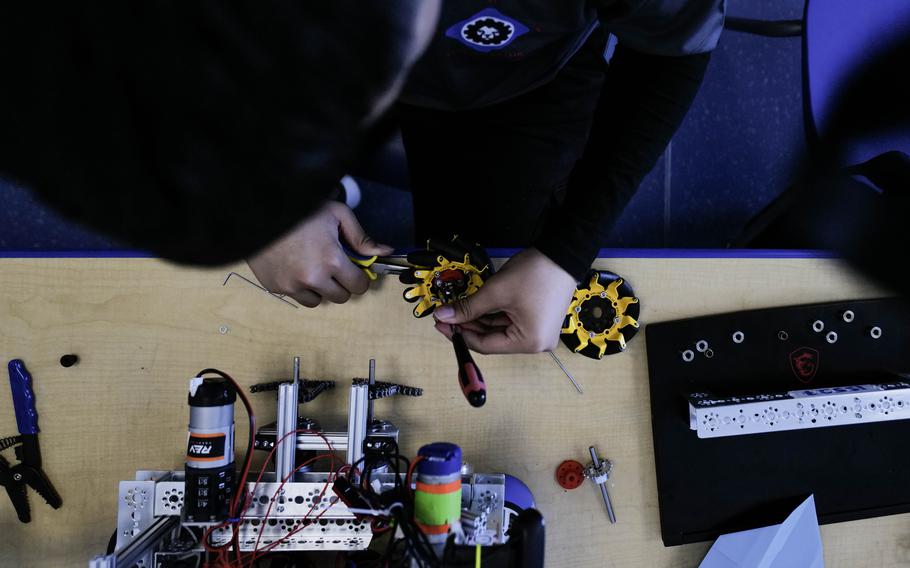 Deylan Acasio readies a wheel to be mounted to a competition robot at Ramstein High School at Ramstein Air Base, Germany, March 18, 2024. The Ramstein robotics team has qualified for the First Tech Challenge World Championships in Houston, Texas, slated for April 17-20.