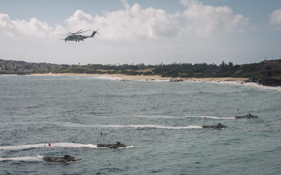 South Korean amphibious assault vehicles head toward the beach as a U.S. Marine Corps CH-53E Super Stallion flies overhead at Marine Corps Base Hawaii during RIMPAC, July 30, 2022.