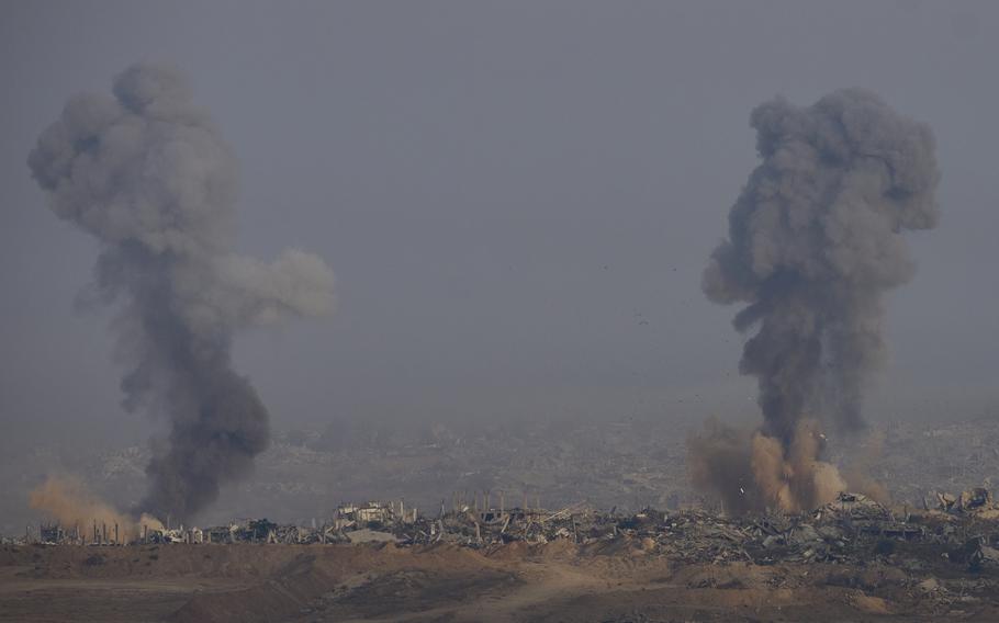 Two plumes of smoke on an expanse of rubble.