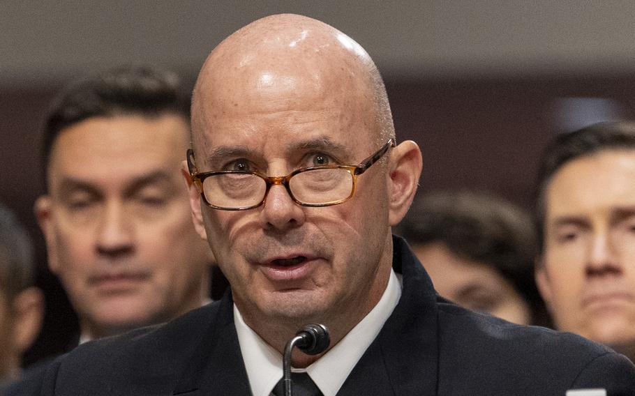 Kilby in uniform and wearing eyeglasses speaks into a microphone.