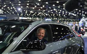 FILE - President Joe Biden drives a Cadillac Lyriq through the showroom during a tour at the Detroit Auto Show, Sept. 14, 2022, in Detroit. Biden, a self-described “car guy,'' often promises to lead by example by moving swiftly to convert the sprawling federal fleet to zero-emission electric vehicles. But efforts to help meet his ambitious climate goals by eliminating gas-powered vehicles from the federal fleet have lagged. (AP Photo/Evan Vucci, File)