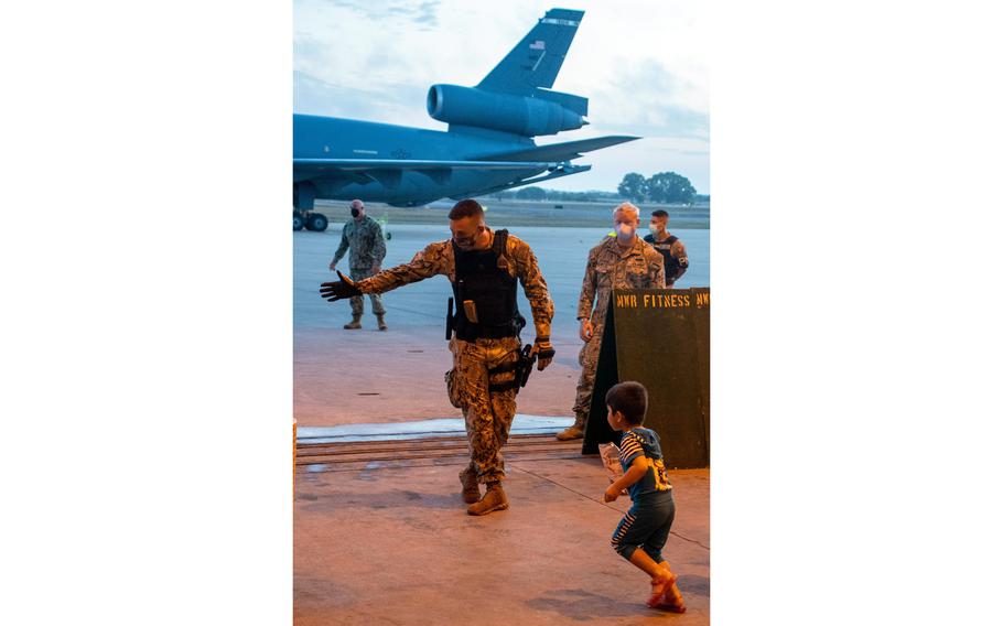 A sailor stationed at Naval Station Rota, Spain, directs a child evacuee from Afghanistan to a check-in station after his arrival at the base aboard a U.S. Air Force KC-10 Extender, Sept. 1, 2021.