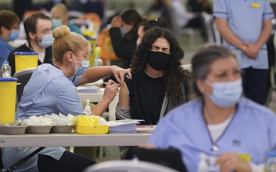 Ghadeer Mahar grimaces as she is given a vaccination at a COVID-19 booster vaccination centre at Hampden Park vaccination centre in Glasgow, Scotland, Wednesday Dec. 29, 2021. (Andrew Milligan/PA via AP)