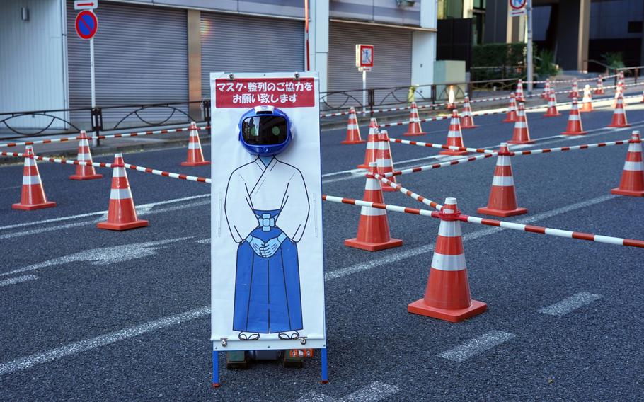A sign reminding visitors to wear masks outside the Kanda Myojin shrine on the first business day of the year in Tokyo on Jan. 4. 