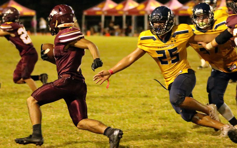 Father Duenas' Cade Taitano evades the tackle of Guam High's Randy Angoco.