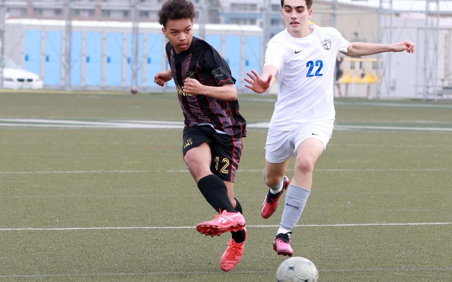 Nile C. Kinnick's Cameron Giddens kicks the ball against Christian Academy Japan's William Arjmandpour. The Red Devils won Tuesday's Kanto Plain boys soccer match 7-1.
