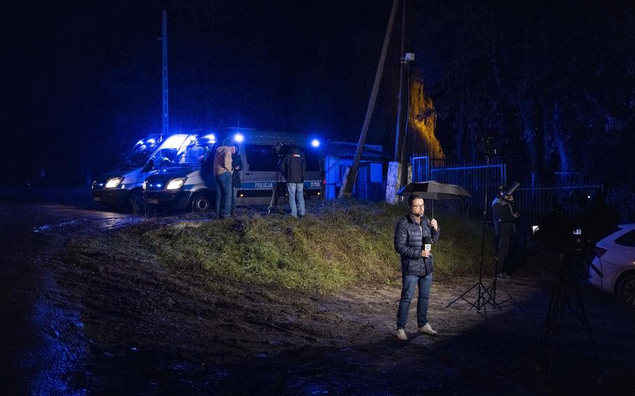 A television reporter stands near the spot where a missile killed two people in Poland. 