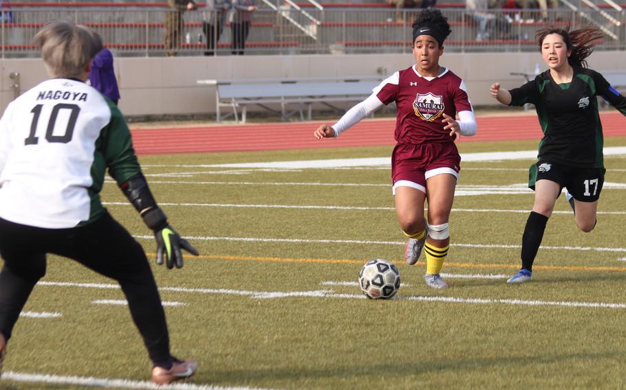 Matthew C. Perry's Ivanelis Nieves-Bermudez tries to outrun Nagoya International's Otoha Yasui and closes in on goalkeeper Mei-yi Cheng during Friday's Western Japan Athletic Association girls soccer tournament. The Samurai won 3-1.