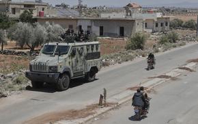 Syrian government security forces sit on their armored vehicle at Busra al-Harir village in Daraa, as they prepare to enter Sweida province where clashes erupted between Druze militias and Sunni Bedouin clans, southern Syria, Monday, July 14, 2025. (AP Photo/Omar Sanadiki)