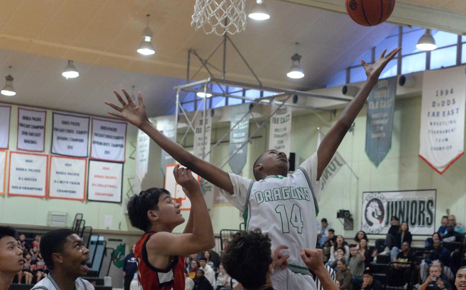 Kubasaki's Alex James skies to rebound over a sea of Okinawa Christian International players and his teammates during Tuesday's Okinawa boys basketball game. The Dragons beat the Eagles 66-52.