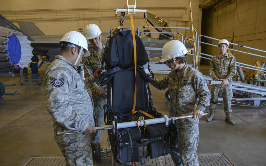 Airmen guide an F-35A Lightning II ejection seat onto a cart at Luke Air Force Base, Ariz., Jan. 11, 2018.