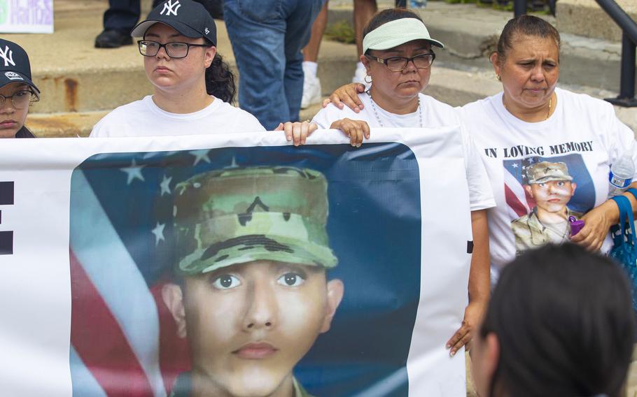 Sister Jennifer Ramirez, left, and Lourdes Lara, mother of Chrys Carvajal, the 19-year-old National Guard member killed, hold a banner with Carvajal’s photo on it during a rally for peace at Riis Park in the Belmont-Cragin neighborhood of Chicago on July 24, 2021. 