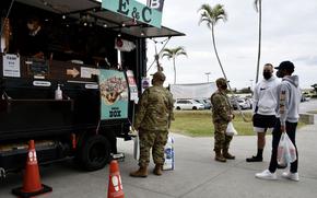 A service member buys lunch from a food truck at Kadena Air Base, Okinawa, Jan. 21, 2022. 