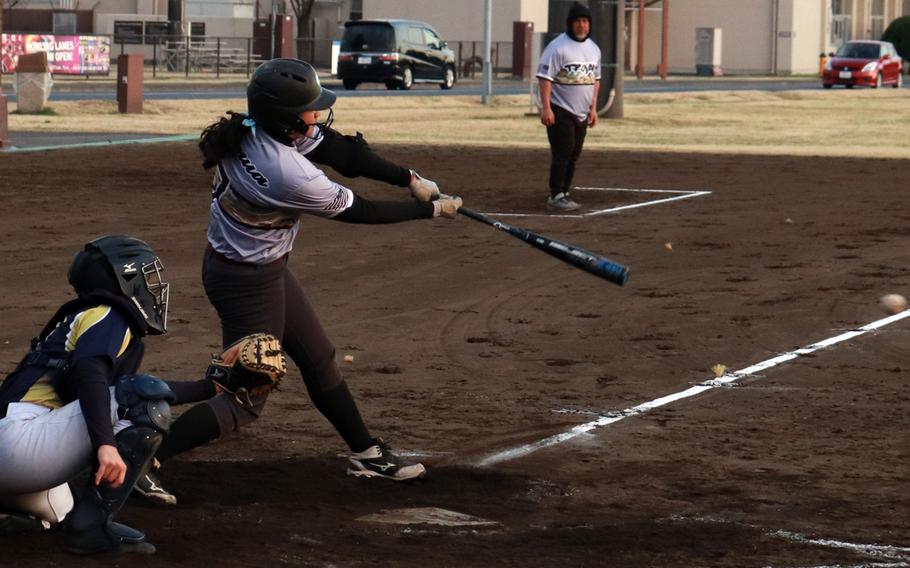 Zama’s Kierstyn Aumua hits a ground ball up the middle against St. Mary’s during Tuesday’s Kanto Plain baseball game. The Trojans won 9-5, their eighth straight win, making them 9-1 on the season.