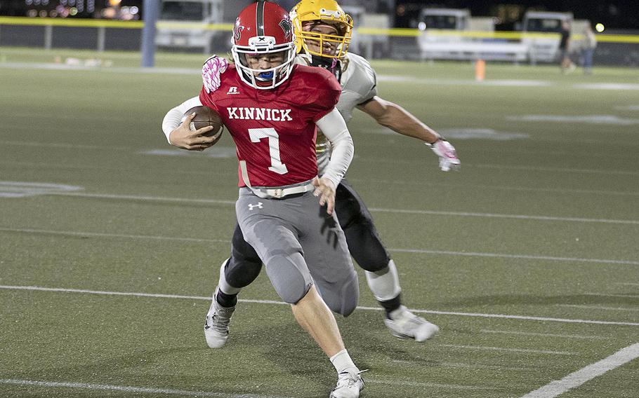 Nile C. Kinnick quarterback Zeke DeLaughter tries to elude Robert D. Edgren defender Douglass Tackney.