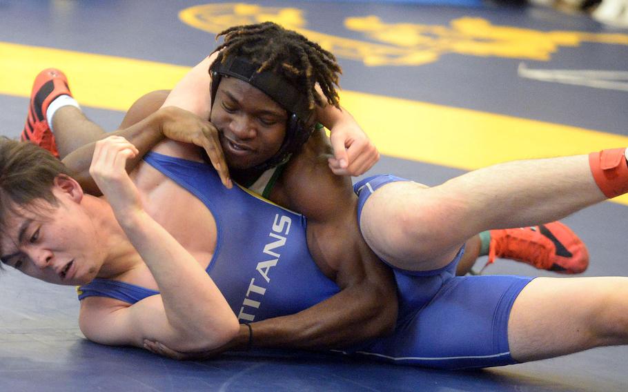 Kubasaki’s Godfrey Wray gains the upper hand on St. Mary’s Taiyo Mitsuoka in the 140-plus-pound final during Tuesday’s Azabu Ward year-end international open wrestling tournament. Wray won by technical fall 12-2 in 4 minutes, 12 seconds, to win the title.